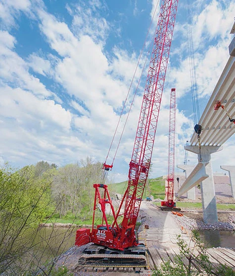 Two crawler cranes working on a bridge