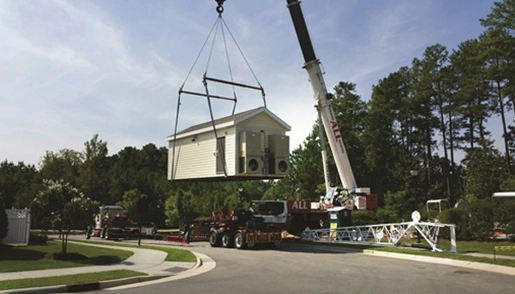 Crane lifting a small building