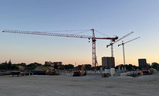 Crane lifting a beam with the ALL logo on it