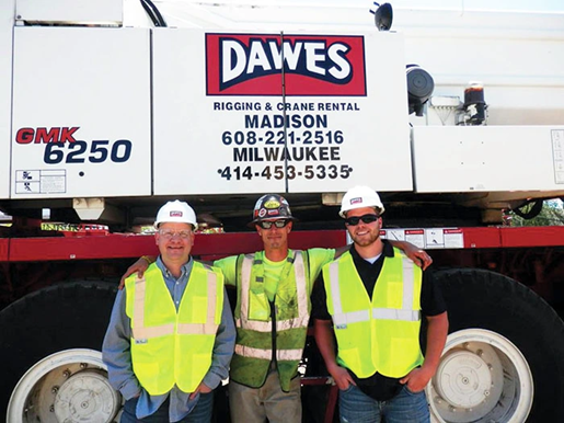 Three men standing in front of a Dawes truck