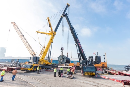 Cranes holding a 230,000 pound reel full of electrical cable