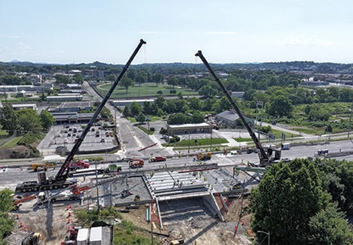 Two large cranes working on a bridge