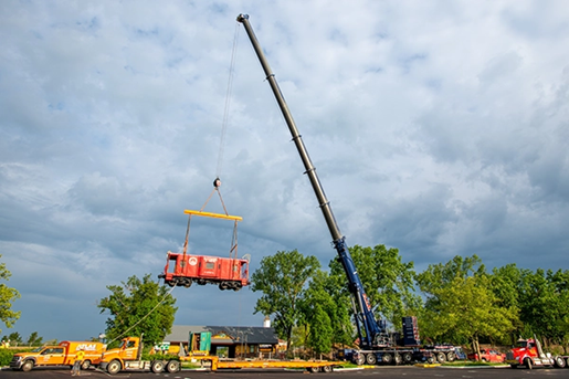 Blue Beast all-terrain crane lifting train caboose