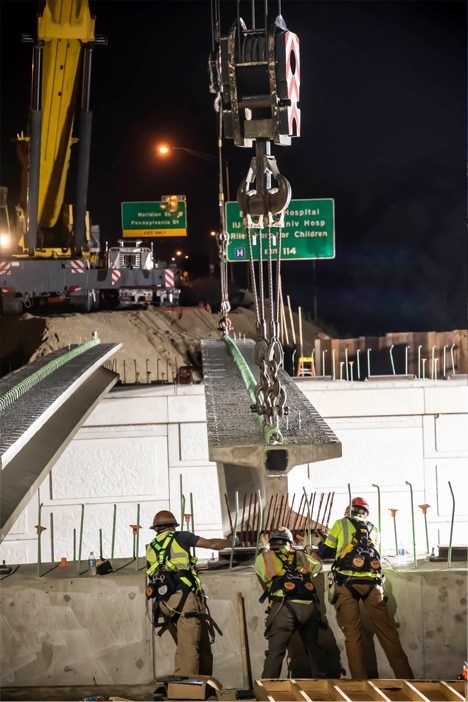 Workers and crane working on road at night