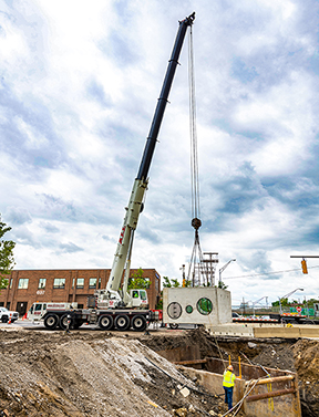 Link-Belt ATC-3275 placing new precast drainage structure