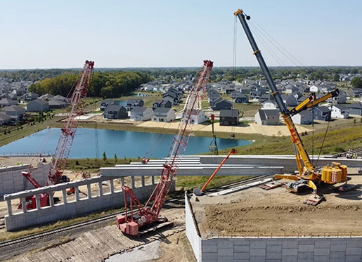 Three cranes working on a bridge