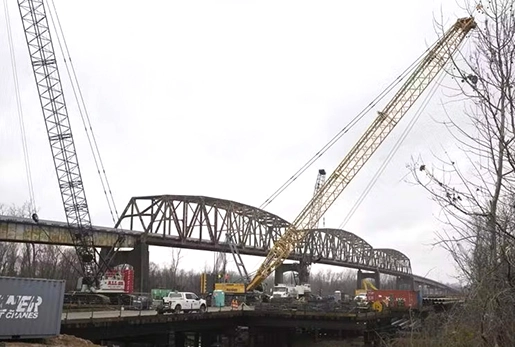 Two lattice crawler cranes working on a bridge