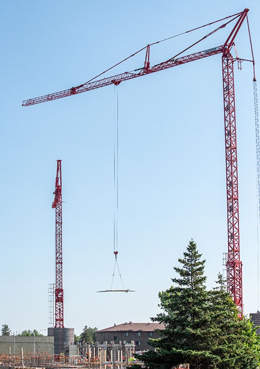 Two red tower cranes on jobsite