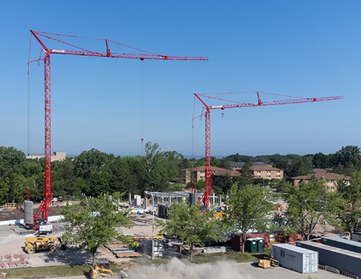 Two red tower cranes on jobsite