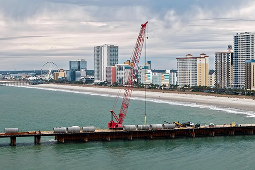 Crawler crane working on a dock on the ocean