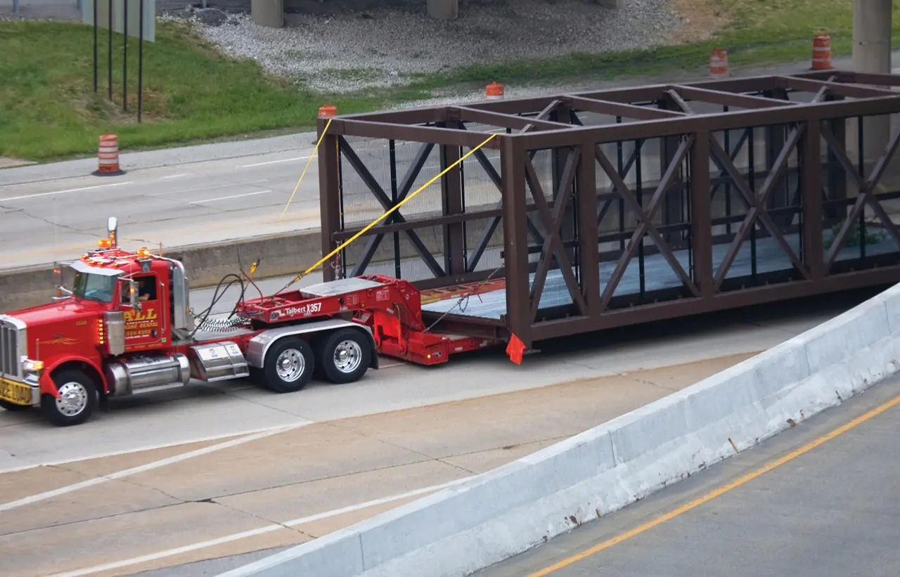 A truck hauling equipment bought from a crane sales company.