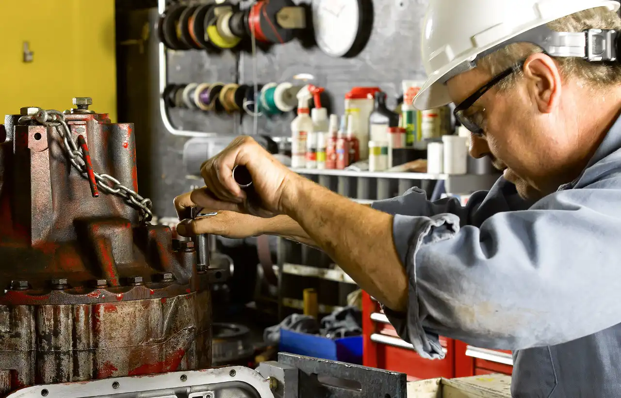 A worker maintaining crane parts and attachments from a crane sales company.